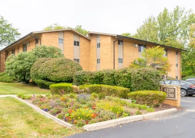 Wyndham hills apartment community building side angle with bushes and flowers.