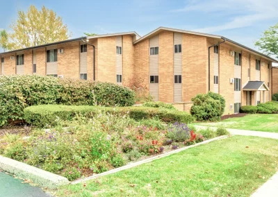 Wyndham hills apartment community building flower bed and bushes on side angle of building wyndhamhills_5_v2